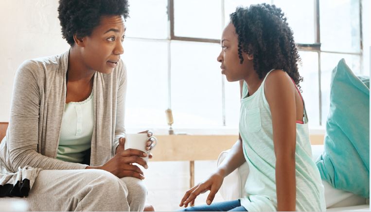 mother and young girl looking at each other and talking to each other 