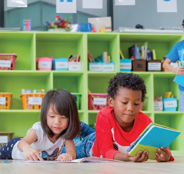 boy and a girl laying down reading each a book 