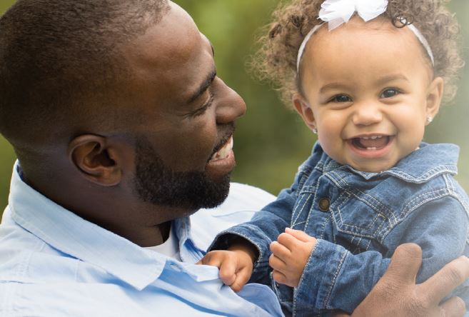 parent holding and laughing with the baby girl 