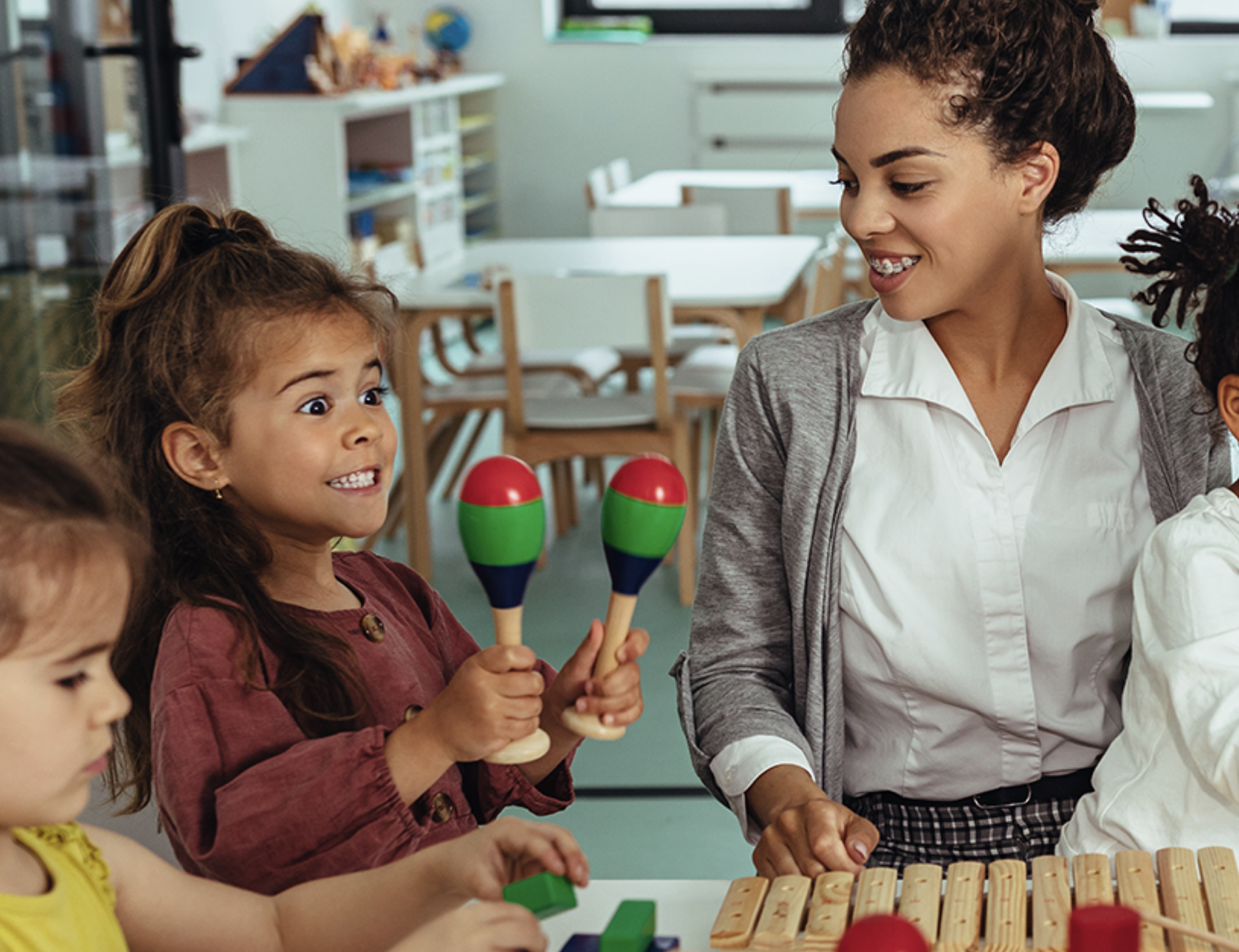 Child playing while teacher watches.