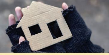 hand holding  a cardboardbox house 