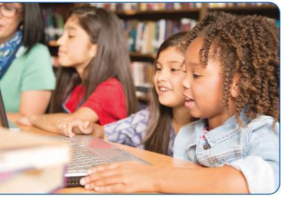 two children together in front of a computer