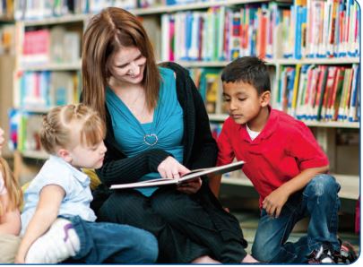  librarian is reading with a girl and a boy 